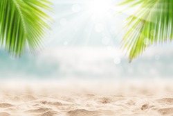 Blurred blue sky and sea with bokeh light and leaves of coconut palm tree. Landscape of tropical summer. Summer vacation concept.