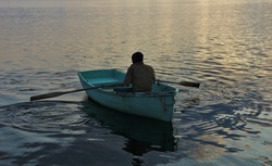 A man sitting in a blue rowing boat. 