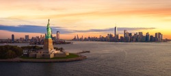 Liberty statue in New York city with manhatttan background and sunset, New York, USA