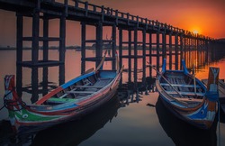 Sunset in U Bein bridge with vintage boat, Myanmar. U Bein bridge is longest teak