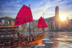 Vintage sail boat fron victoria port to Hongkong harbour for survice to tourist in Hong kong coty with sunset and blue sky, China, Travel asia and cityscape concept