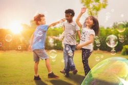 Kid and friends in international preschool play a bubble in playground with sunset background, kid, child, school, play and summer background