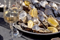 Opened oysters and champagne glasses on a table at open-air party.