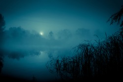 Night mystical scenery. Full moon over foggy river.