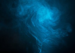 Blue smoke over black studio background