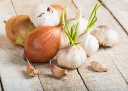 Garlic and onion on wooden background. Selective focus.