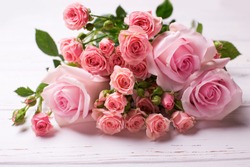Bunch of tender pink roses flowers  on  white wooden background. Floral still life.  Selective focus. 