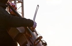street musician cello plays music outdoors