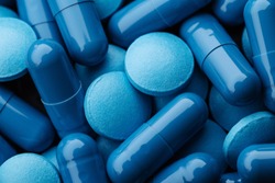Close up of blue pills capsules. Medicine and pharmacy concept.