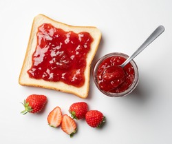 A bird's-eye view of the strawberry jam-filled bread and strawberry fruit on a white background