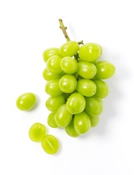 Bunches of Shine-Muscat grapes and cut Shine-Muscat grapes on a white background. White grapes. Japanese grapes. View from above.