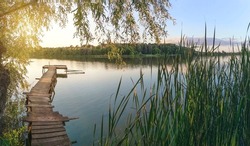 Lake panorama with fishing pier at sunset