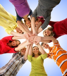 Large group of smiling friends staying together and looking at camera isolated on blue background