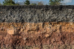 The curb erosion from storms. To indicate the layers of soil and rock.