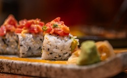 Macro sushi roll of spicy raw Tuna on a beautiful stone plate, healthy Japanese food, soft-focus sushi roll in dark mood image.