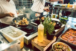 High-angle view of various fresh ingredients on the stove and the counter of a commercial kitchen in a trendy restaurant with fish specialties
