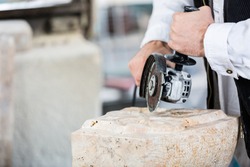 Close-up of stonemason cutting marble with angle grinder
