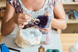 Woman brushing an amethyst in her workshop