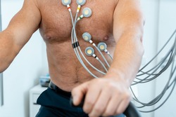 Patient on exercise bike with electrodes during ECG