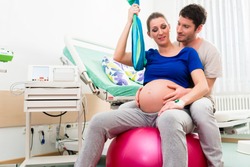 Pregnant woman and man in delivery room of hospital