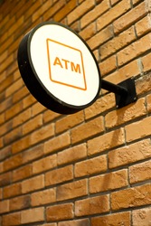 Circle shape ATM sign on brick wall