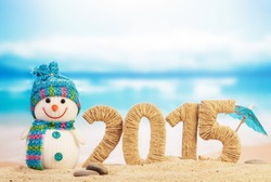 New year 2015 sign with snowman on beach background