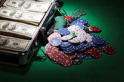 Suitcase with dollars and  near casino chips on green cloth
