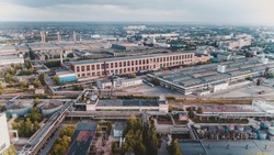 Old chemical factory with oil storage tank, pipes and refinery workshop, aerial view
