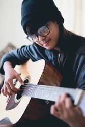 Closeup young asian girl play acoustic guitar