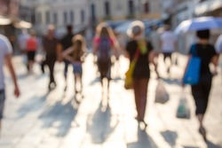 CROWD OF BLURRED PEOPLE HOLDING SHOPPING BAGS WALKING IN THE CITY STREET AT BEAUTIFUL SUNNY DAY, LIFESTYLE BACKGROUND