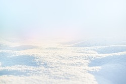 WHITE SNOW IN SUN LIGHT ON LIGHT BLUE FROSTY SKY, BRIGHT WINTER BACKDROP BACKGROUND WITH EMPTY SNOWY FIELD SPACE FOR MONTAGE OR DISPLAY, COLD NATURE LANDSCAPE