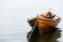 Old wooden row boat on water