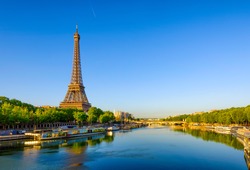 View of Eiffel Tower and river Seine at sunrise in Paris, France. Eiffel Tower is one of the most iconic landmarks of Paris. Architecture and landmarks of Paris. Postcard of Paris