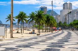 View of Leme beach and Copacabana beach with palms and mosaic of sidewalk in Rio de Janeiro, Brazil. Copacabana beach is the most famous beach in Rio de Janeiro. Sunny cityscape of Rio de Janeiro
