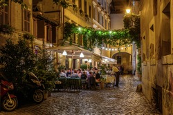 Night view of old cozy street in Trastevere in Rome, Italy.  Trastevere is rione of Rome, on the west bank of the Tiber in Rome, Lazio, Italy.  Architecture and landmark of Rome