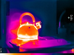 Thermal image photo ir, kettle on gas stove, color scale.