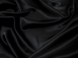 Black fabric texture background, wavy fabric slippery black color, luxury satin cloth texture.