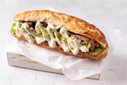 Baguette Asian fusion vegan sandwich with fermented and fresh vegetables on textured white