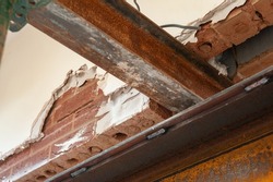 Exposed load bearing wall with steel needle used to support it during steal beam installation. 