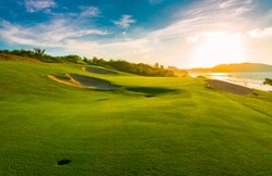 Sand bunkers at the beautiful golf course at the ocean side at sunset, sunrise time.