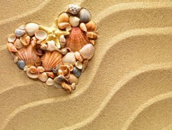 Heart made of sea shells and the starfish lying on a beach sand summer background