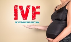 IVF In vitro fertilisation. Pregnant woman pointing to text.