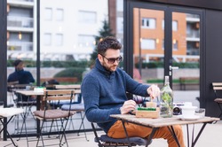 Young man drinking coffee at coffee shop garden