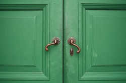 Door handles with an old double wood door green