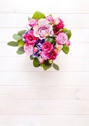 flowers. bouquet of roses in a bucket on a white wooden background