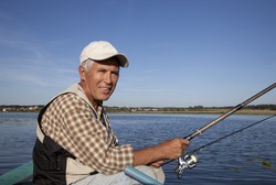 Portrait of senior fisherman with fishing rod in his hands