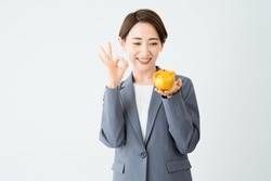Business image of a young woman holding a piggy bank and making an OK sign