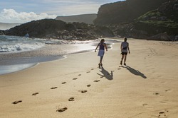 two women walking on the beach