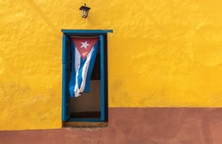 Cuban flag hanging on a door in Trinidad, Cuba