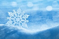 Christmas background with a decorative snowflake on brilliant snow